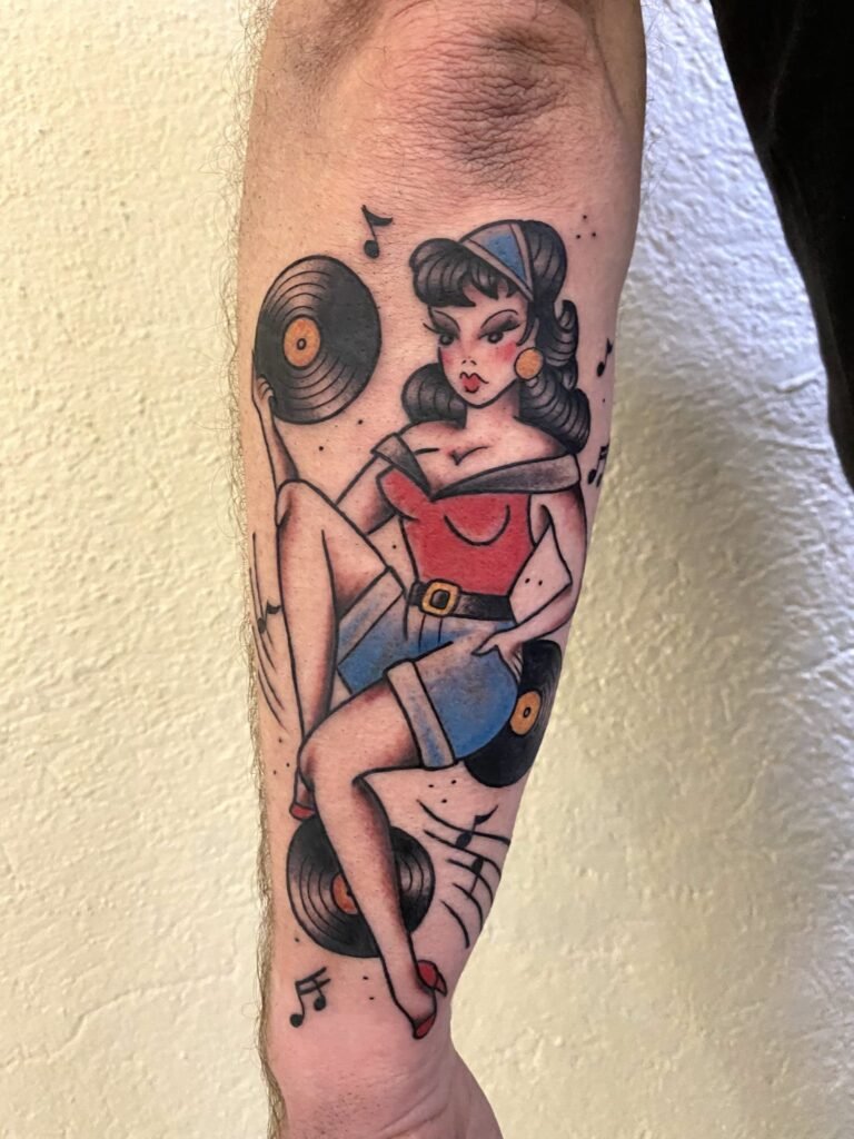 Tatouage pin-up oldschool avec vinyles et notes de musique sur le bras. Pin up old school tattoo par vittoriatattoo, creuse 23