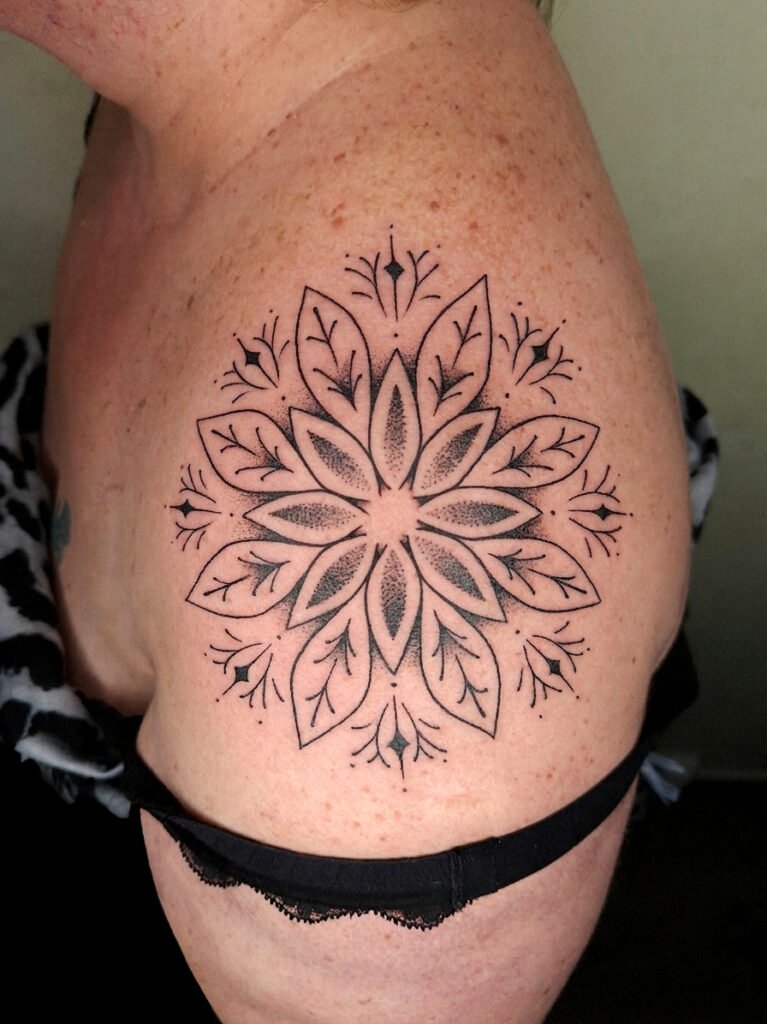 Tatouage d'un mandala Floral en Dotwork circulaire aux motifs floraux situé sur l'épaule, réalié au salon vittoriatattoo dept 23 creuse