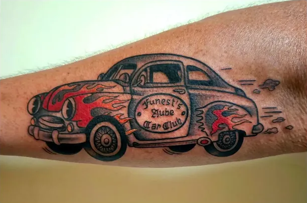 Tatouage old school représentant une voiture Hot Rod vintage rouge avec des flammes et des détails rétro