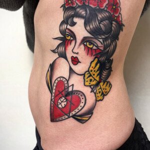 Tatouage old school réalisé par vittoria tattoo. Passion, douleur et renaissance réunies dans une muse old school au cœur indélébile.