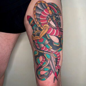 Tatouage old school représentant un serpent enroulé autour d’un poignard.