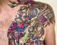 Tatouage coloré inspiré d’Alice au pays des merveilles avec personnages et champignons sur l’épaule et le torse, réalisé à Aubusson par Vittoria Tattoo.