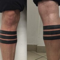 Tatouage bandes noires mollet blackwork minimaliste.