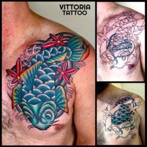 Cover tattoo d’une grosse écriture sur la poitrine réalisé avec une carpe koi old school colorée et des fleurs rouges par Vittoria Tatto